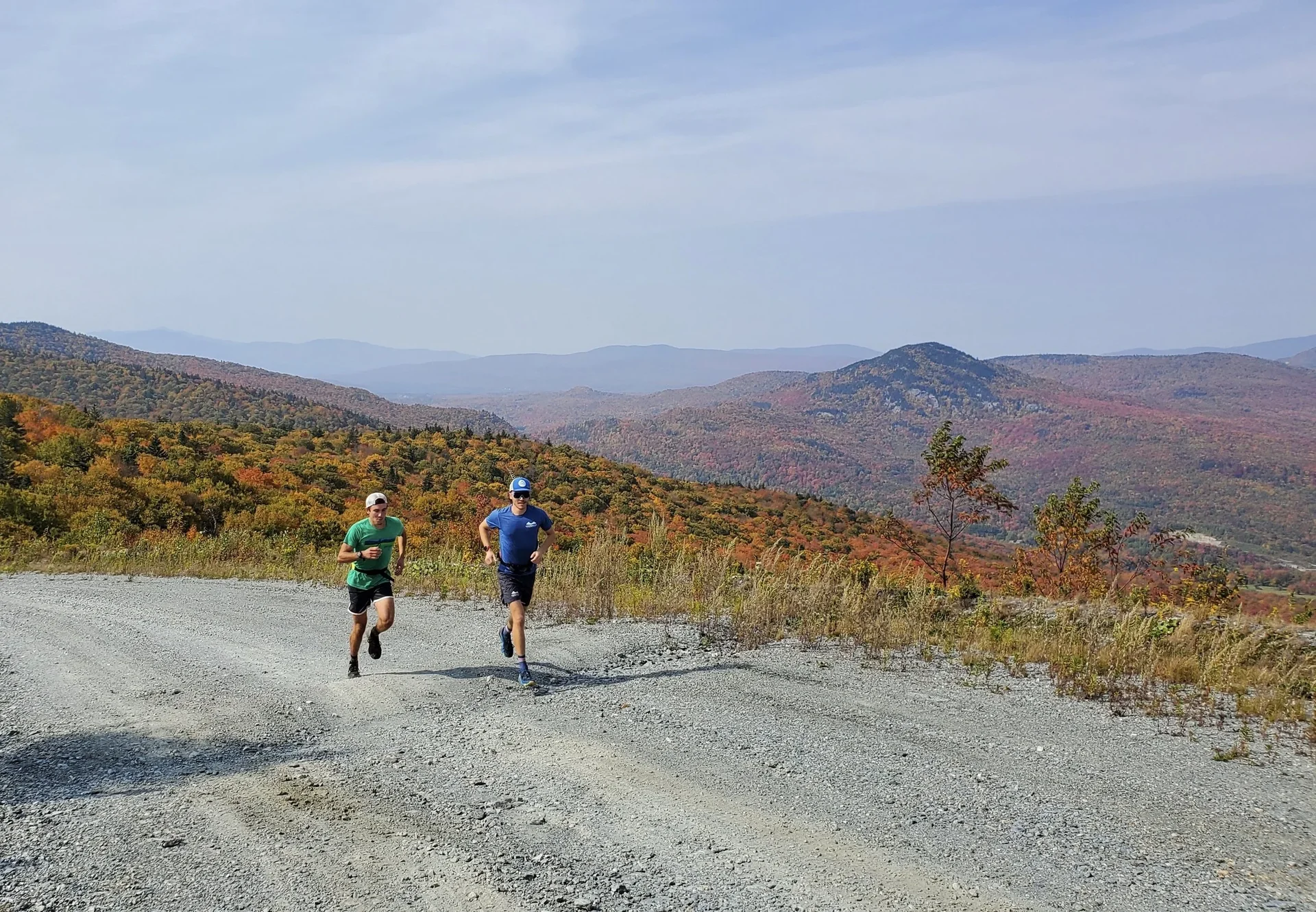 A runner holding a hard tempo on a cinder rail trail in fall.