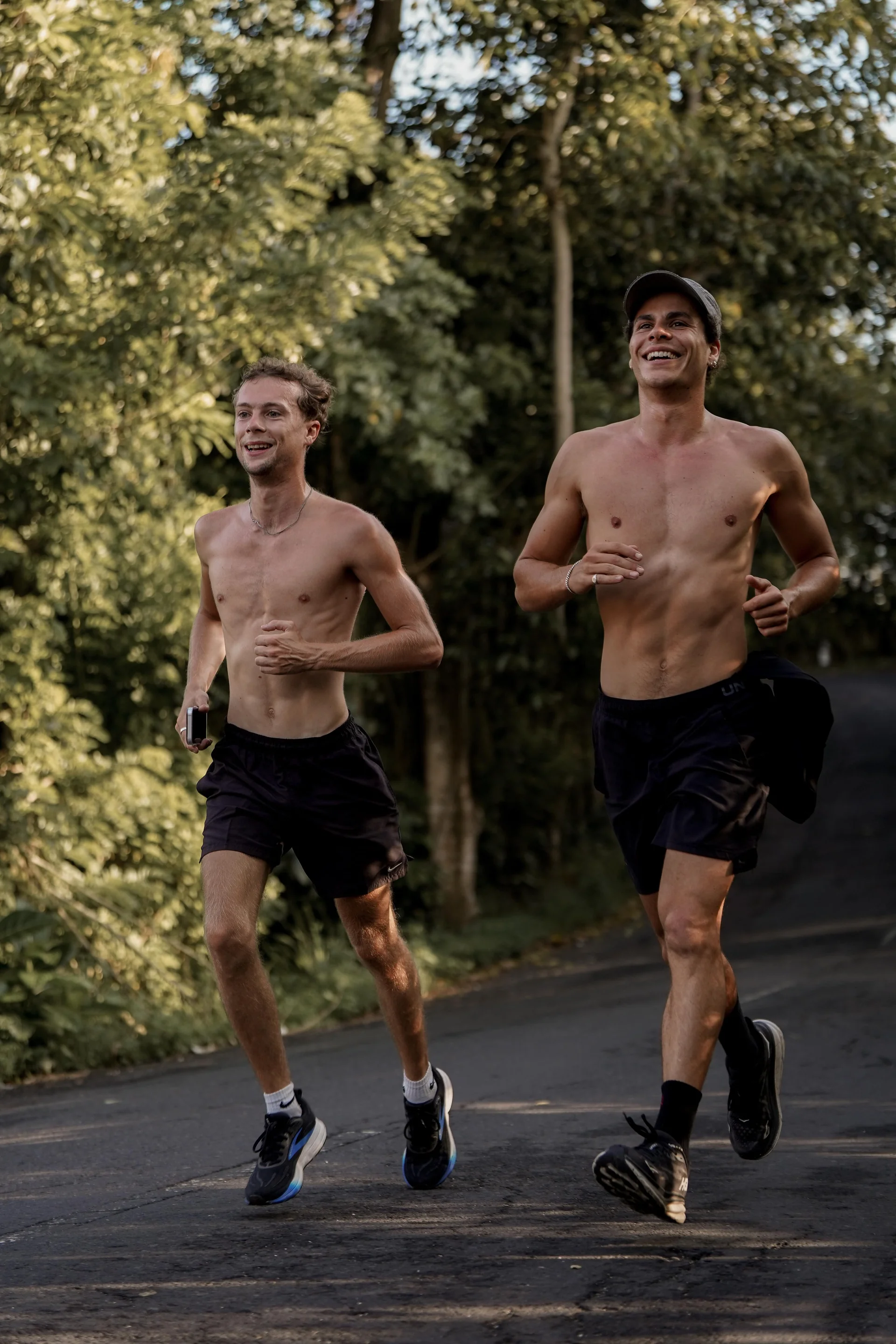 Two runners side by side on a quiet suburban road in the morning.