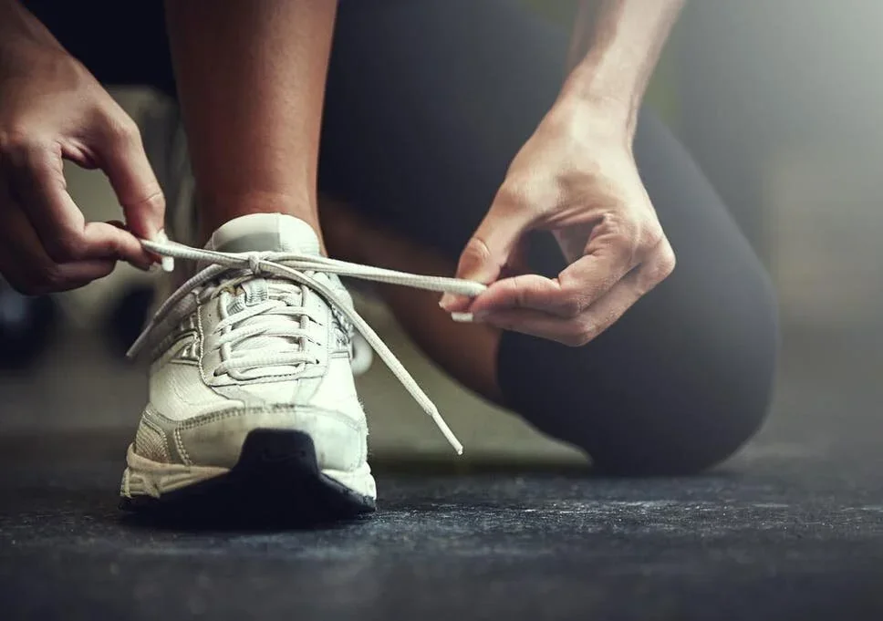 A runner tying their running shoes before heading out.