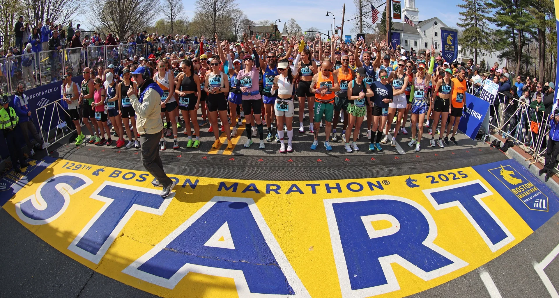 A marathon finish-line arch under a low sun, finisher banners overhead.