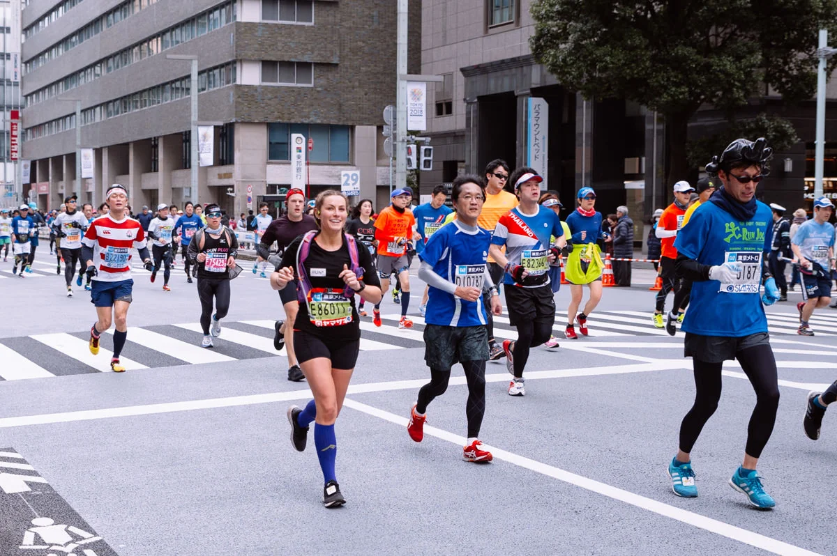 Runners moving through the streets during the race, packed in a colorful group of competitors