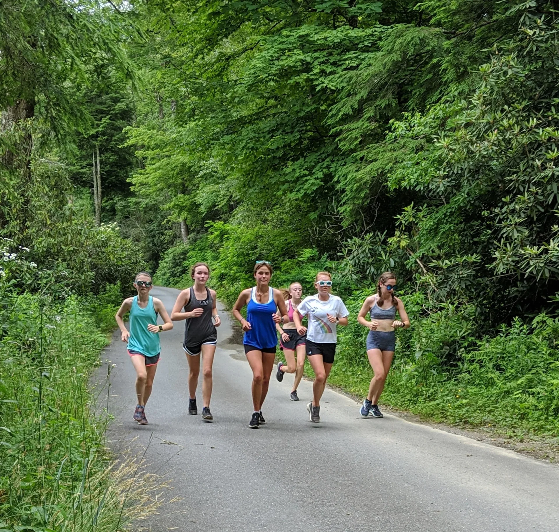 A runner's hand highlighting split times on a printed pace conversion chart at a kitchen table, coffee mug beside it.