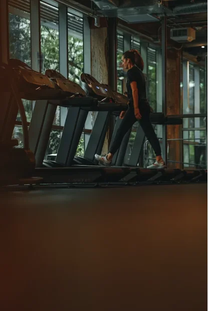 A glowing treadmill console at dawn in a dim home gym, faint sweat droplets on the belt.