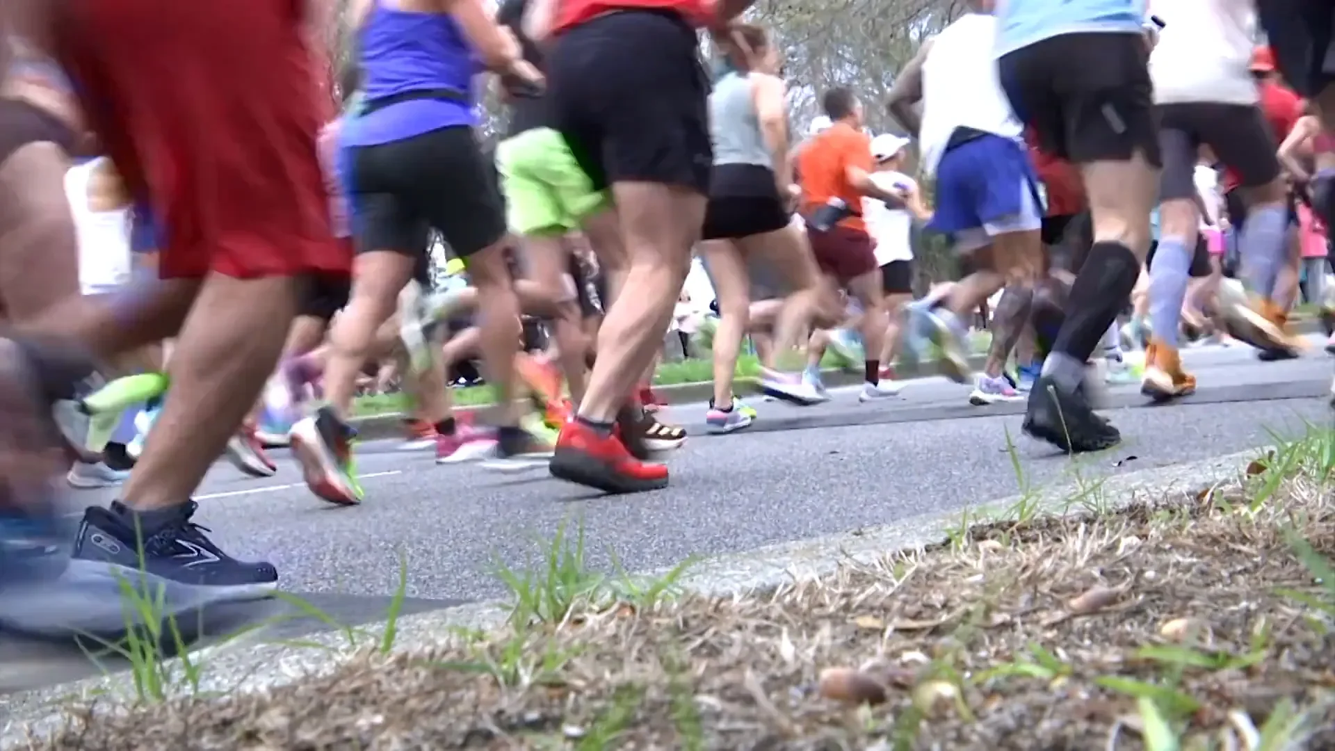 A sports watch on a runner's wrist mid-run showing three stacked pace splits speeding up across the display.