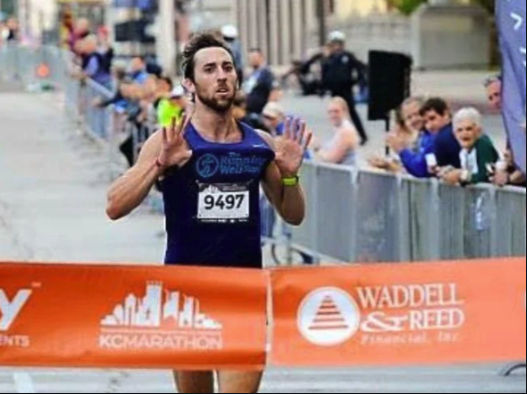 A runner breaking the finish-line tape