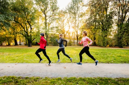 Lauren on a group run with two friends through a fall park